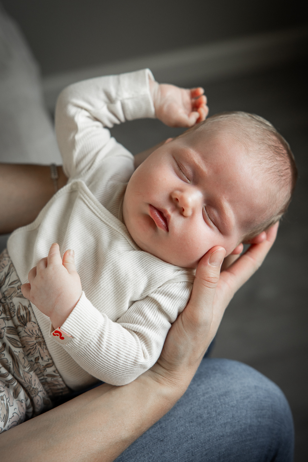 Newborn baby in moeders armen tijdens een newbornshoot thuis